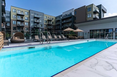 A swimming pool in front of apartment buildings.