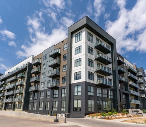 A modern multi-story apartment building with balconies on each floor.