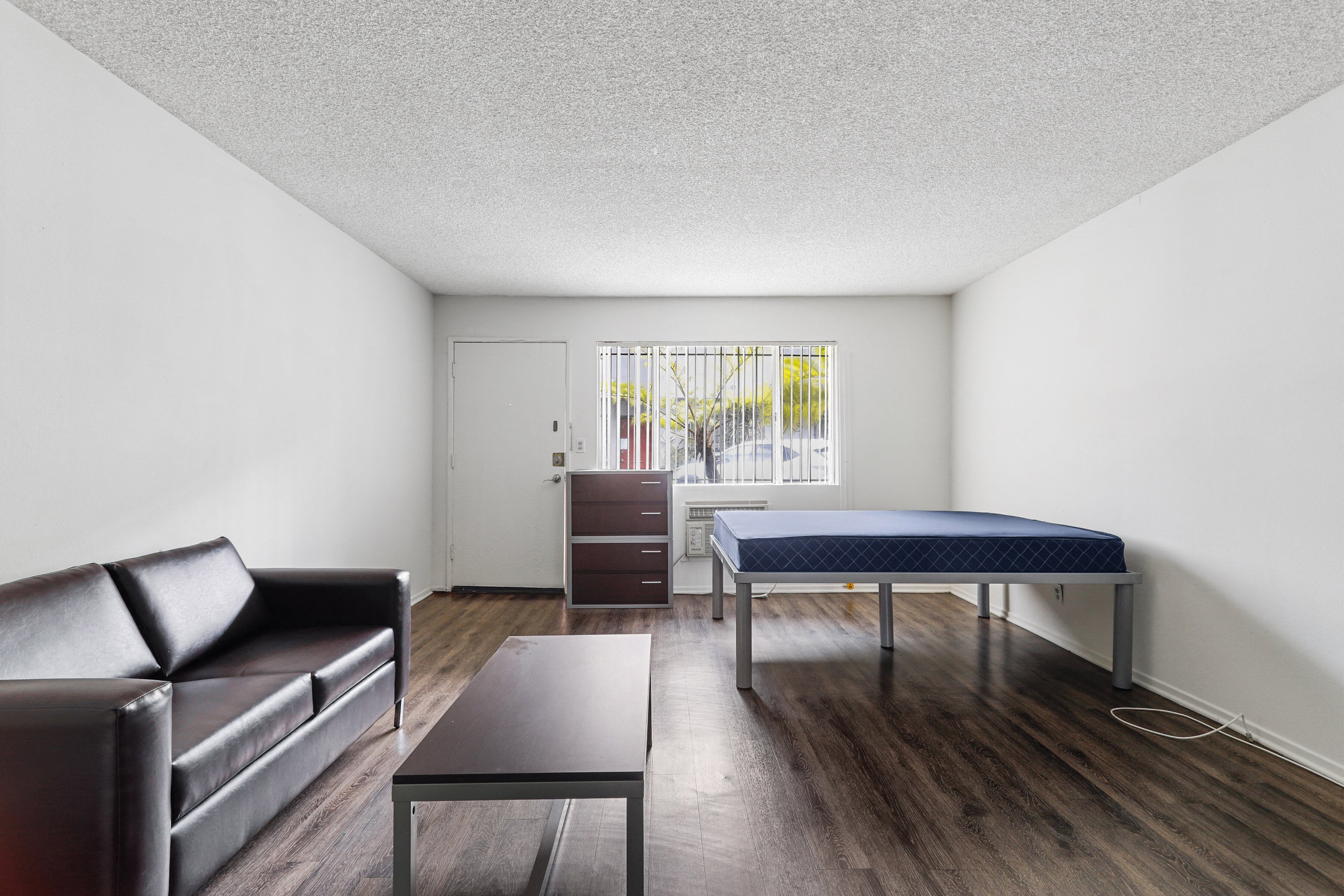 a living room with a couch and a table with a bed