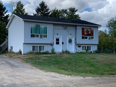 A white house with a Canadian flag on the window.