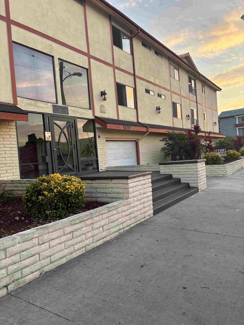 A building with a red and beige facade has a sign that reads "RESIDENTS".