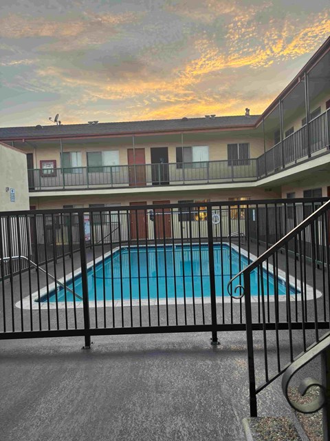 A pool surrounded by a black fence.