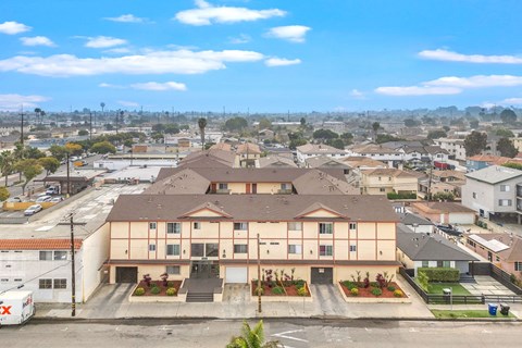 A large apartment complex with a parking lot in front.