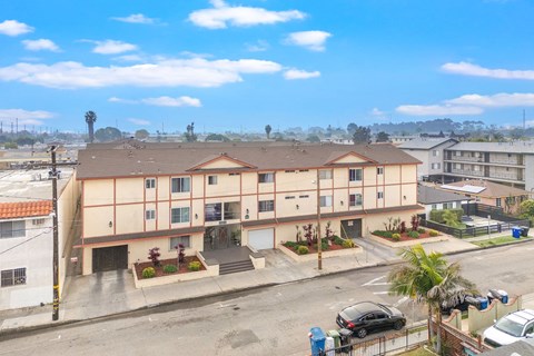A building with a red roof and a parking lot in front.