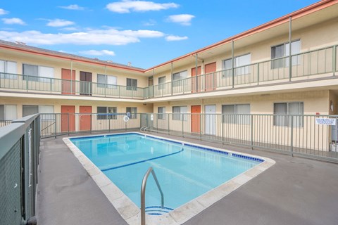 A swimming pool in a courtyard surrounded by apartment buildings.