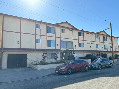 Two cars parked in front of a building with a garage door.