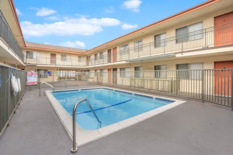 A swimming pool in a courtyard surrounded by apartment buildings.