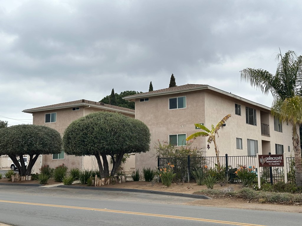 A building with a sign that reads "Pollincrest" is surrounded by greenery.