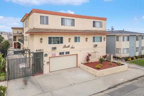A two-story building with a garage and a driveway in front.