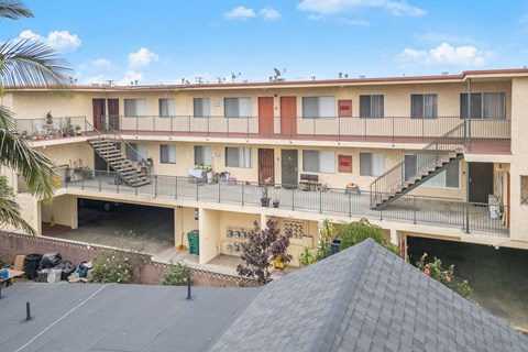 Apartment complex with a grey roof and a balcony.