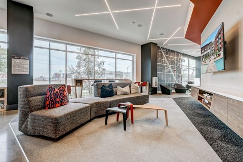 A modern living room with a grey sofa and a wooden coffee table.