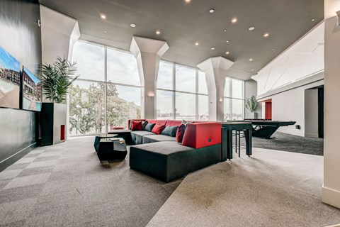 A modern living room with a large table and comfortable seating.