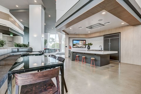 A modern kitchen with a glass table and bar stools.