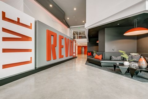 A modern living room with a large couch and a sign that says "REVIEW".