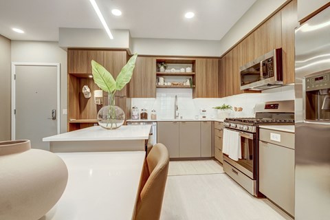 A modern kitchen with a white countertop and stainless steel appliances.