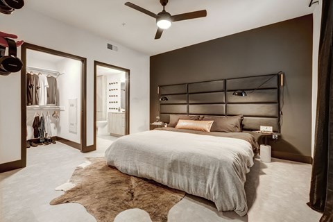 A bedroom with a large bed and a ceiling fan.