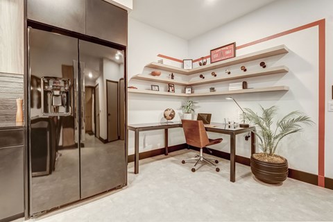 A modern office with a glass door and a brown chair.