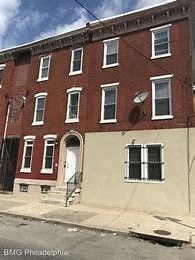 A red brick building with a white door and windows.