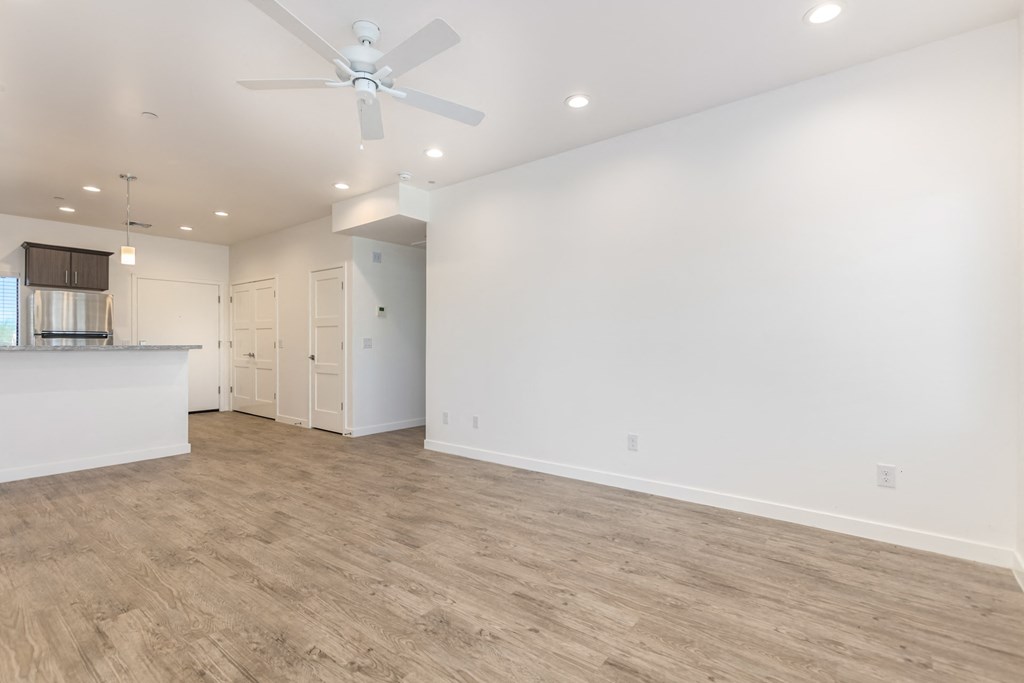 A spacious room with a ceiling fan and lighting fixtures.