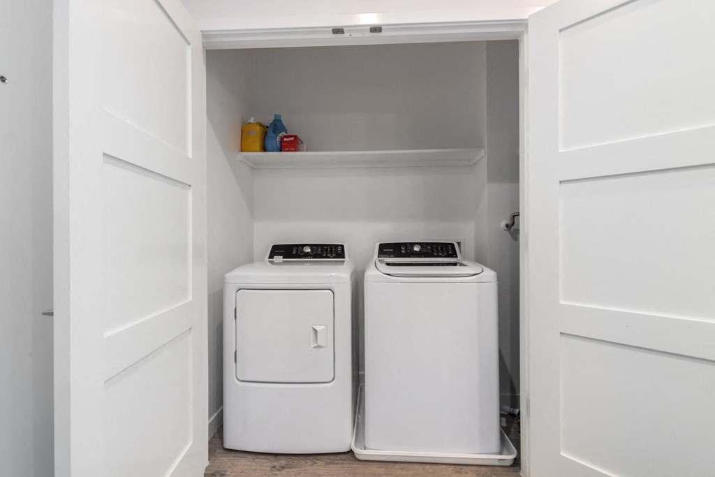 A white laundry room with a washer and dryer.