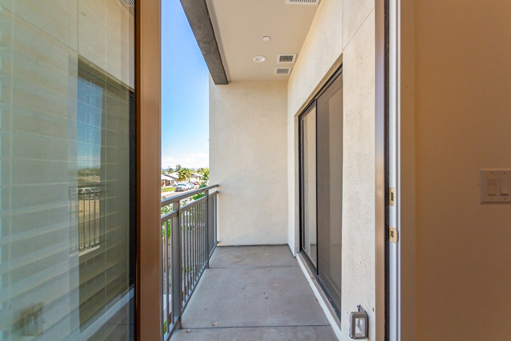 A balcony with a glass door and a metal railing.
