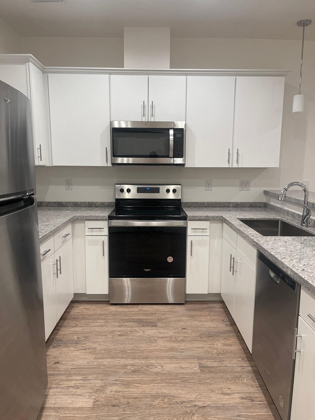 A kitchen with white cabinets and stainless steel appliances.