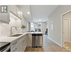 A kitchen with white cabinets and a stainless steel refrigerator.