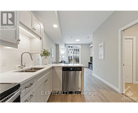 A kitchen with white cabinets and a stainless steel refrigerator.