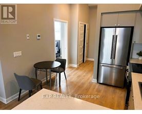 A kitchen with white cabinets and a stainless steel refrigerator.