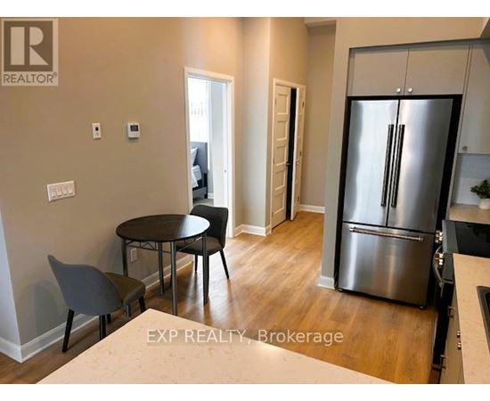 A kitchen with white cabinets and a stainless steel refrigerator.