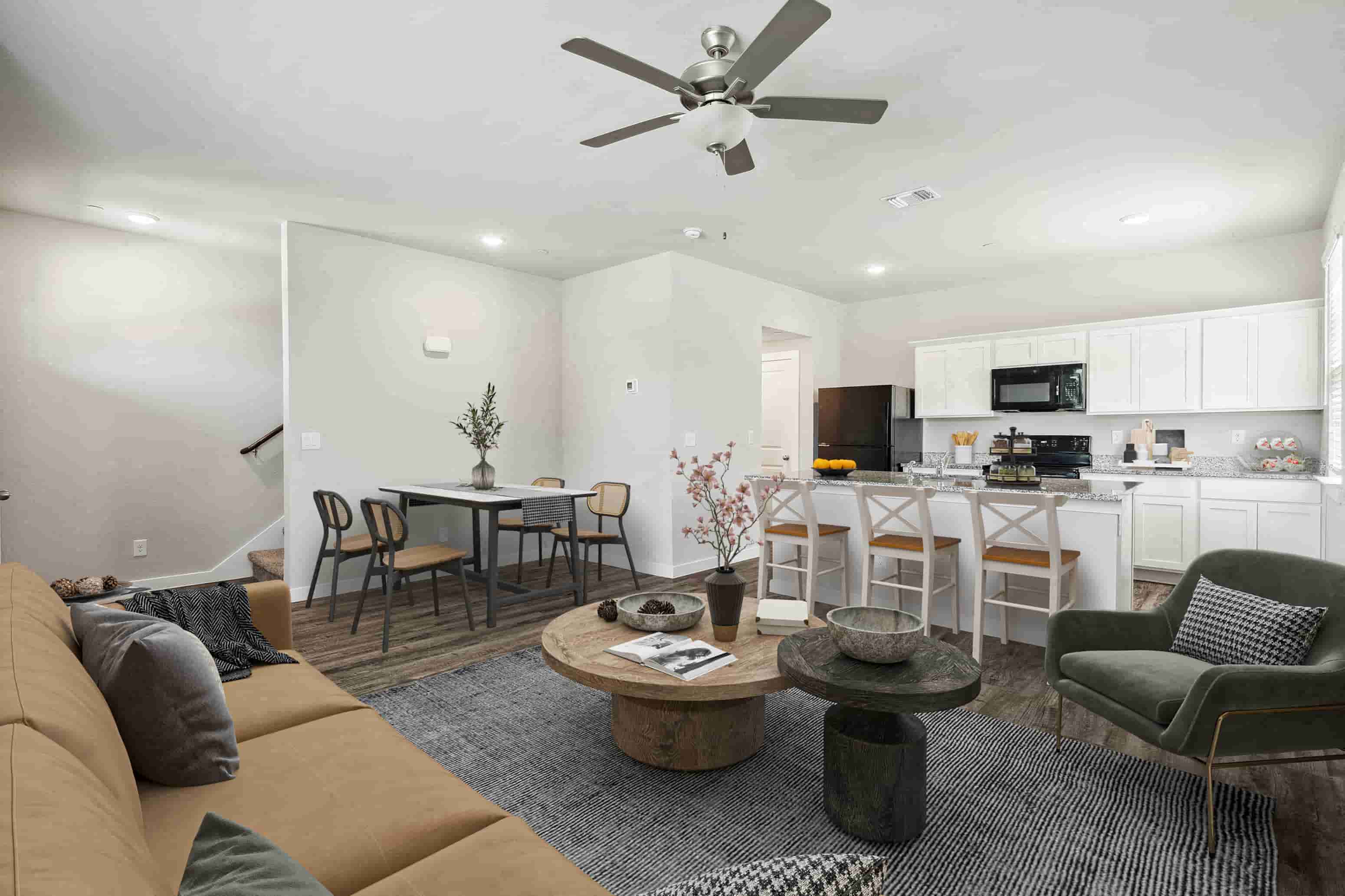 A living room with a couch, chairs, and a dining table.