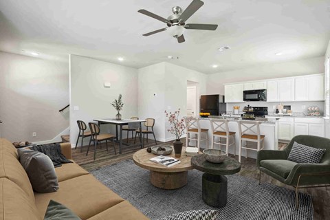 A living room with a couch, chairs, and a dining table.