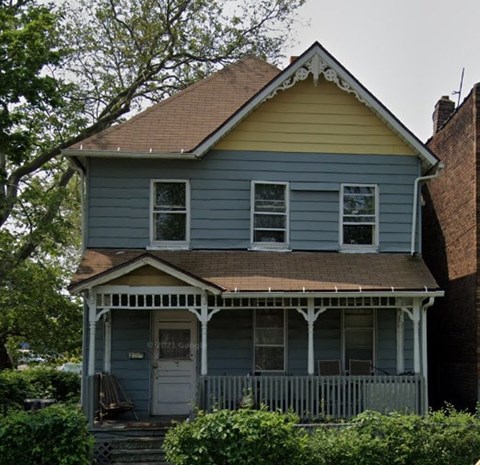 A small house with a porch and a front door.