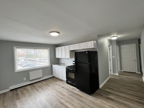 A kitchen with a black fridge, stove, and oven.