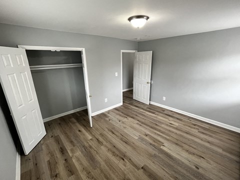 A room with wood flooring and two white doors.