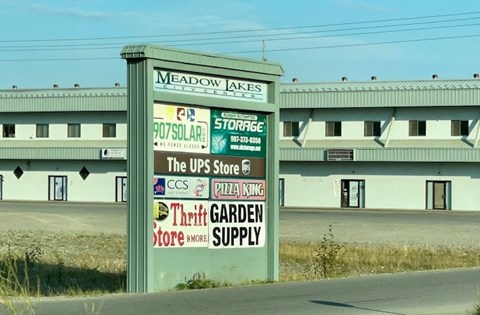 A sign for Meadow Jakes is in front of a building.