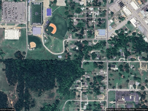 A satellite image shows a football field, a baseball diamond, and a soccer field in a campus setting.