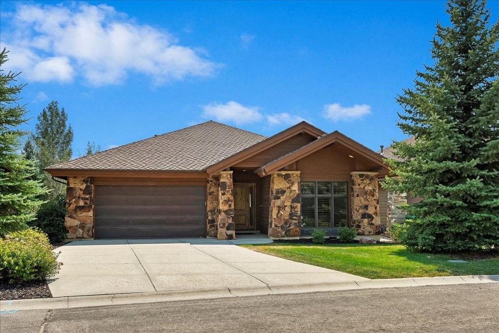 A house with a brown roof and a stone pillar.