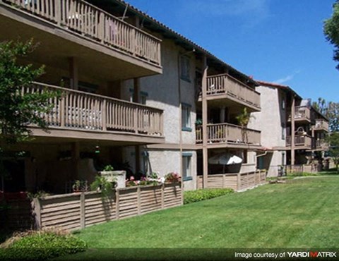 Apartment complex with balconies and green lawns.