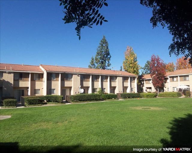 an apartment building with a green lawn in front of it