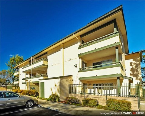A modern two-story building with a car parked in front.