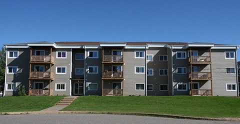 Apartment building with a green lawn in front.