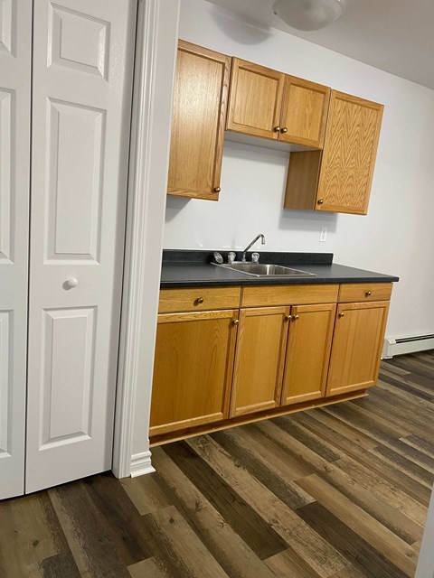 A kitchen with wooden cabinets and a black countertop.