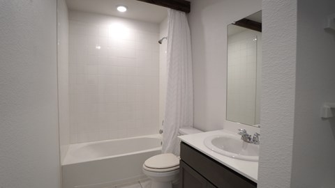 A white toilet sits next to a white sink in a small bathroom.