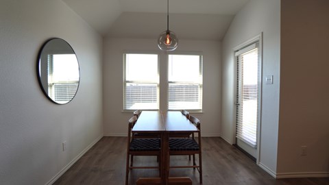 A dining room with a table and chairs.