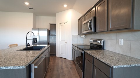 A kitchen with granite countertops and stainless steel appliances.