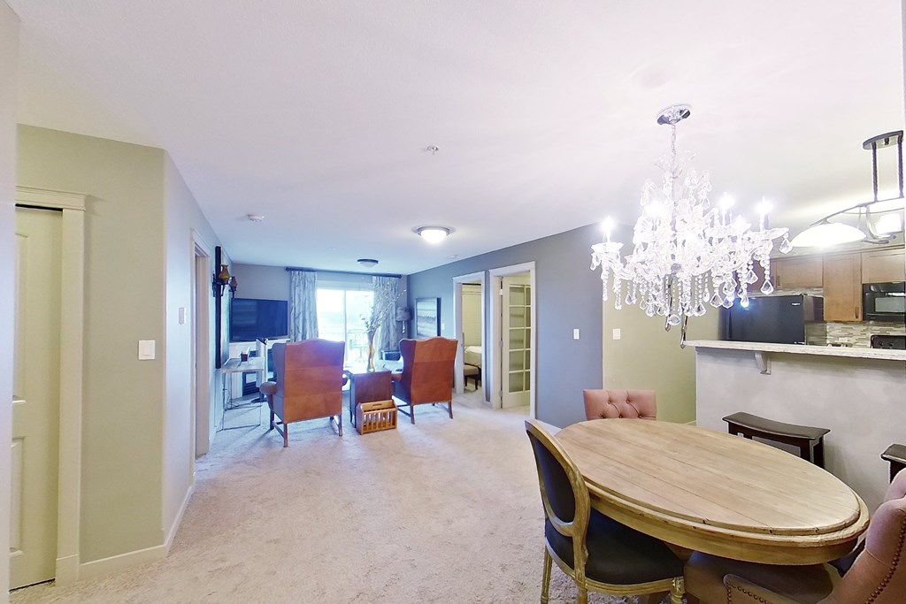 A dining room with a wooden table and chairs.