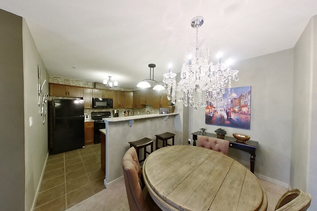 A dining room with a wooden table and chairs.