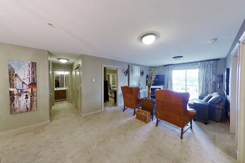 A living room with a painting on the wall and a sofa.