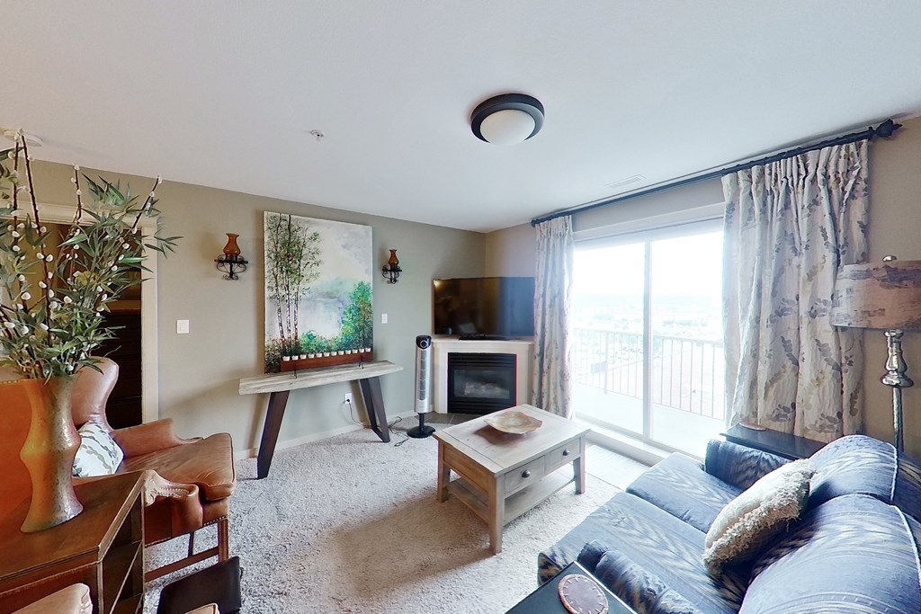 A living room with a couch, a coffee table, a television, and a painting on the wall.